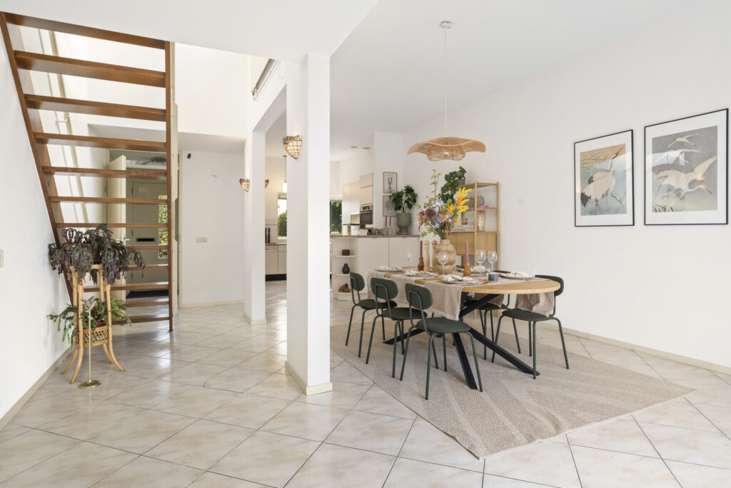 Modern dining area with staircase and art.
