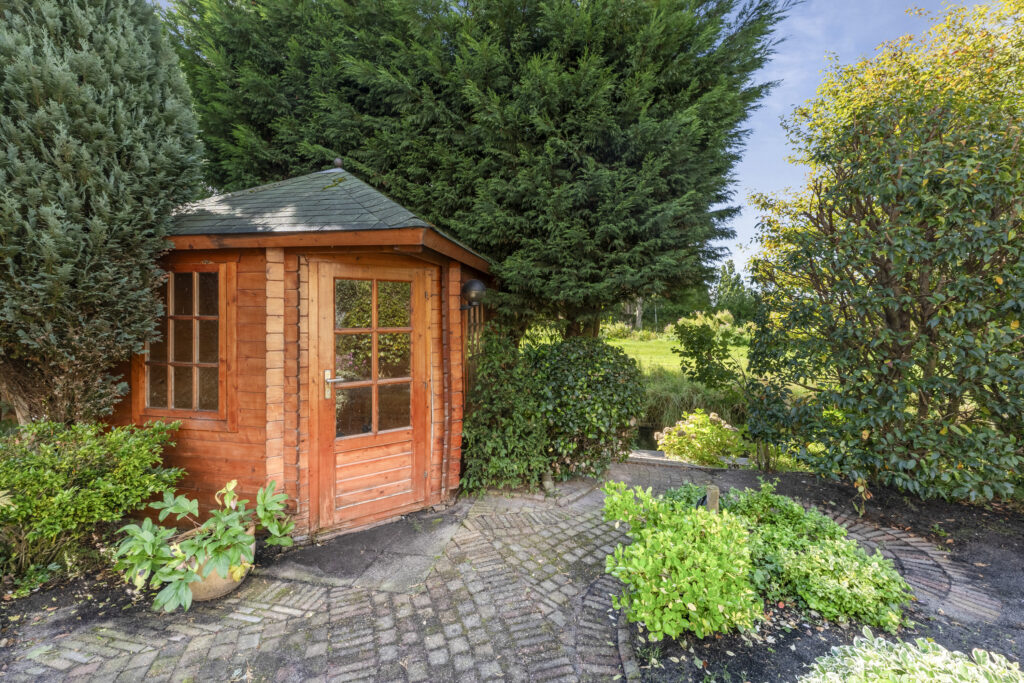 Cozy garden shed surrounded by lush greenery.
