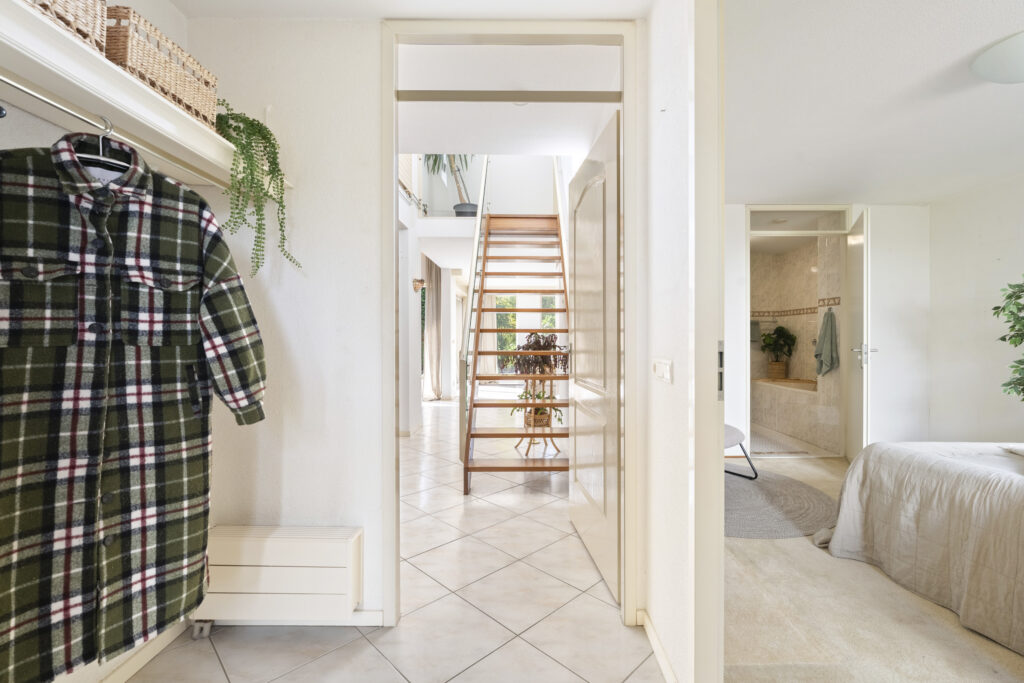 Modern hallway with staircase and bedroom view.