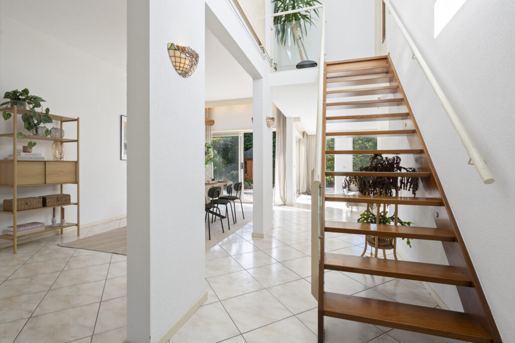 Modern interior with open staircase and dining area.