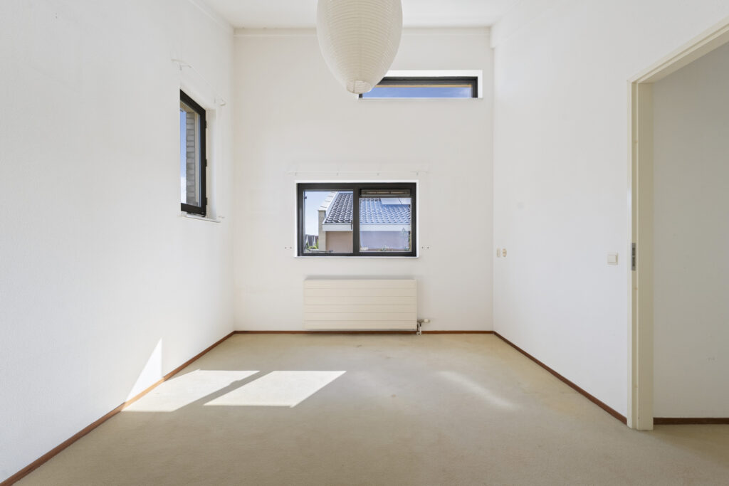 Empty room with windows and radiator.