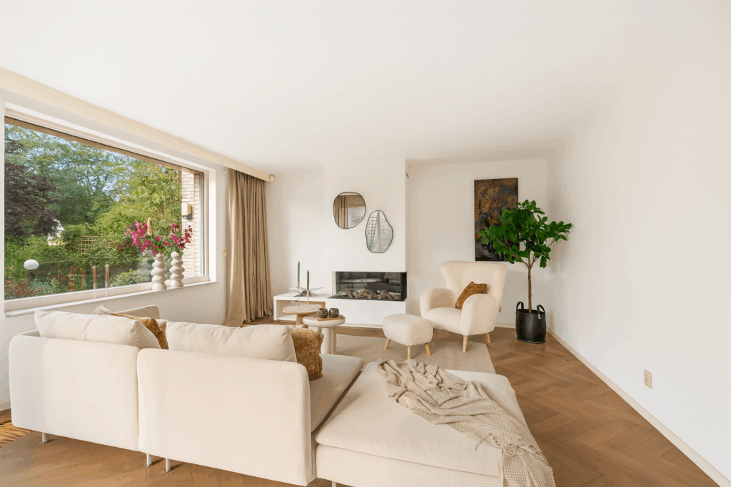 Modern living room with large window and cozy furniture.