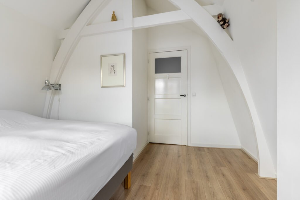 Minimalist white bedroom with arched ceiling