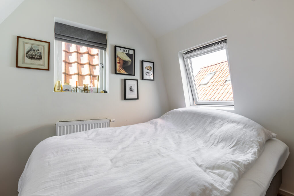 Cozy bedroom with minimalist decor and rooftop view.