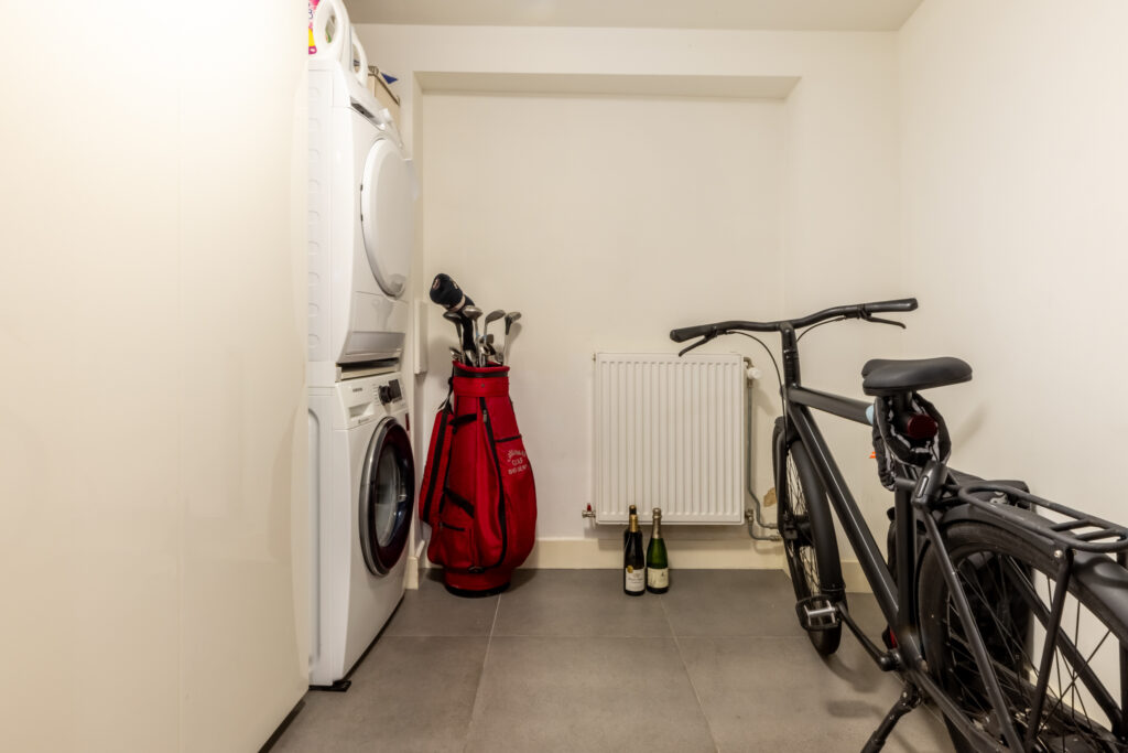 Laundry room with washer, dryer, bike, and golf bag.