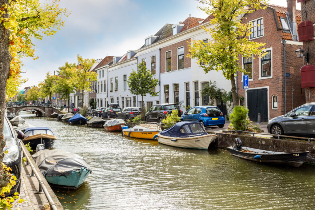 Dutch canal with boats and houses in sunlight.