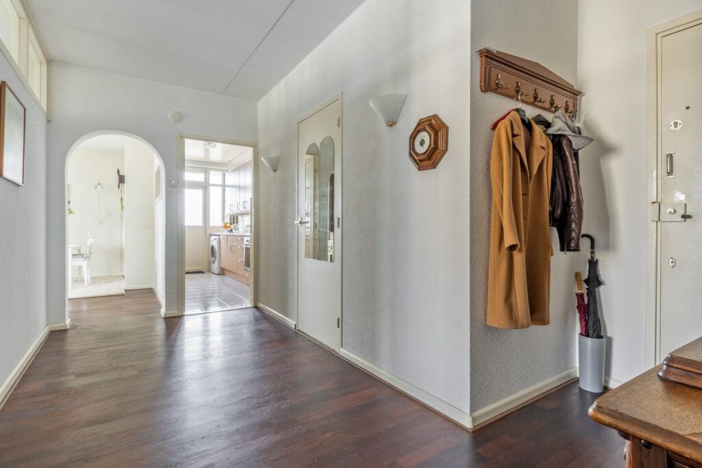 Modern hallway with coat rack and umbrella stand.