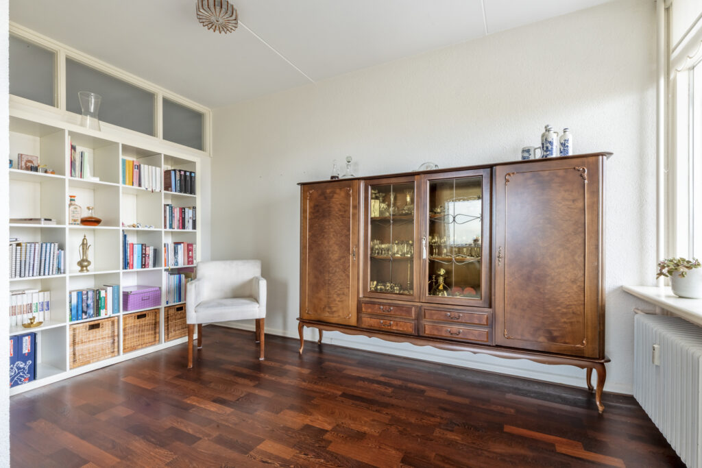 Living room with bookshelf and vintage cabinet.