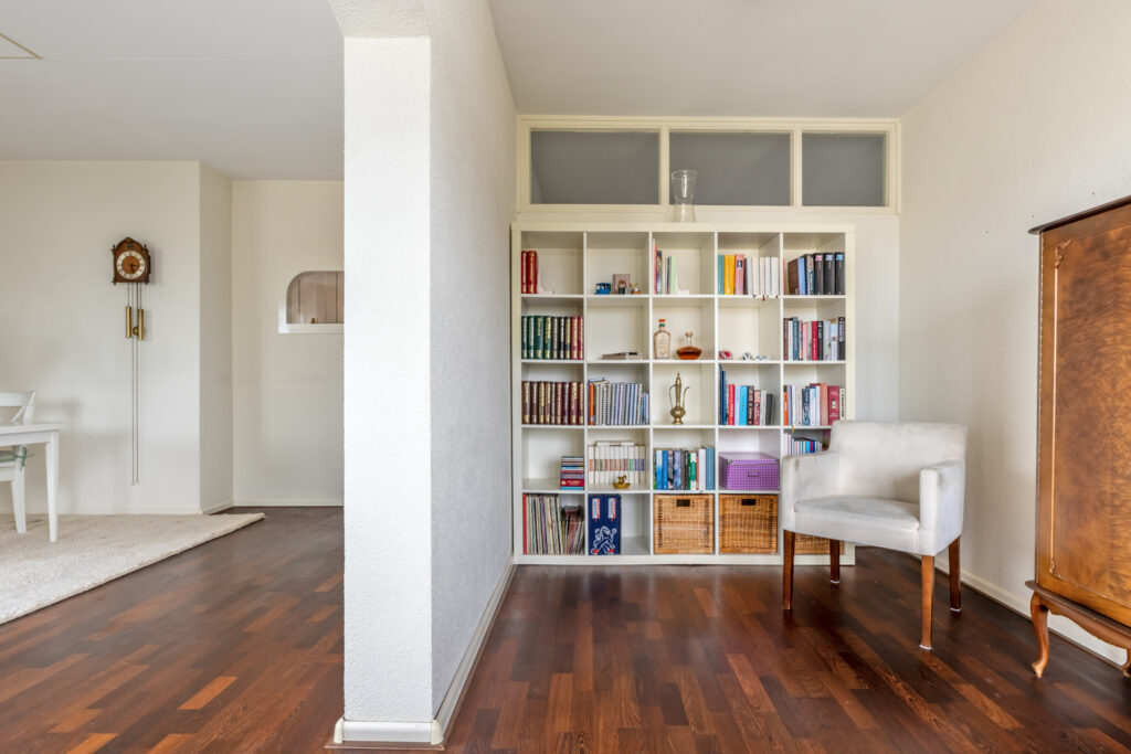 Cozy living room with bookshelf and armchair.