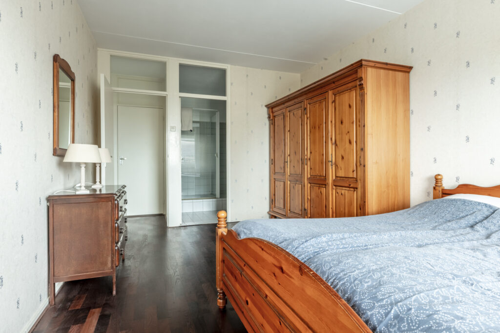 Cozy bedroom with wooden furniture and blue bedding.
