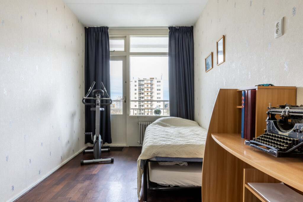 Bedroom with exercise bike and typewriter.