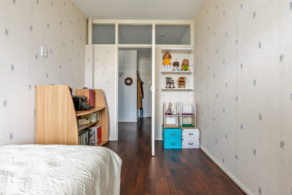 Cozy bedroom with typewriter and bookshelves.