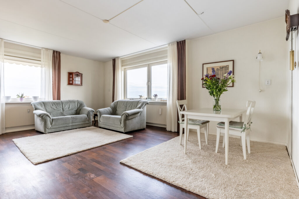 Bright living room with sofas and dining area.