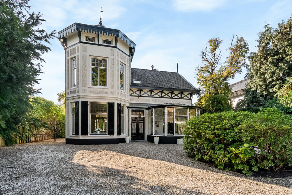 Historic villa with tower and garden in sunlight