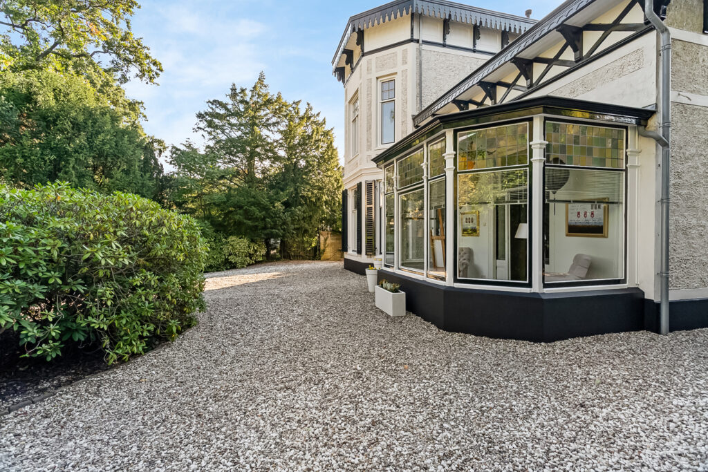 House with gravel driveway and garden view
