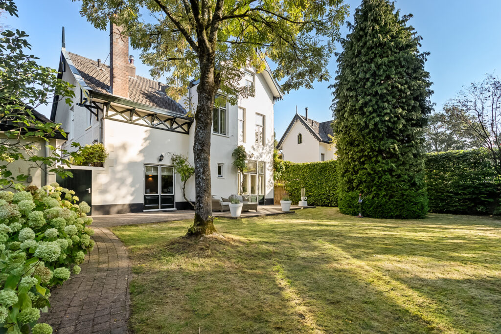 Spacious backyard with garden and white house