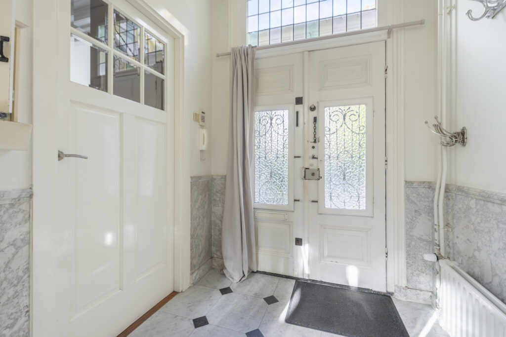 Bright entryway with glass-paneled door and marble floor.