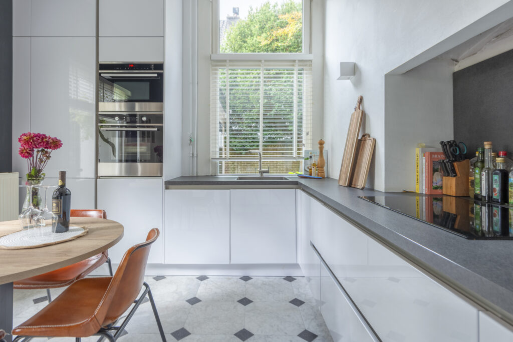 Modern kitchen with white cabinets and wooden accents.