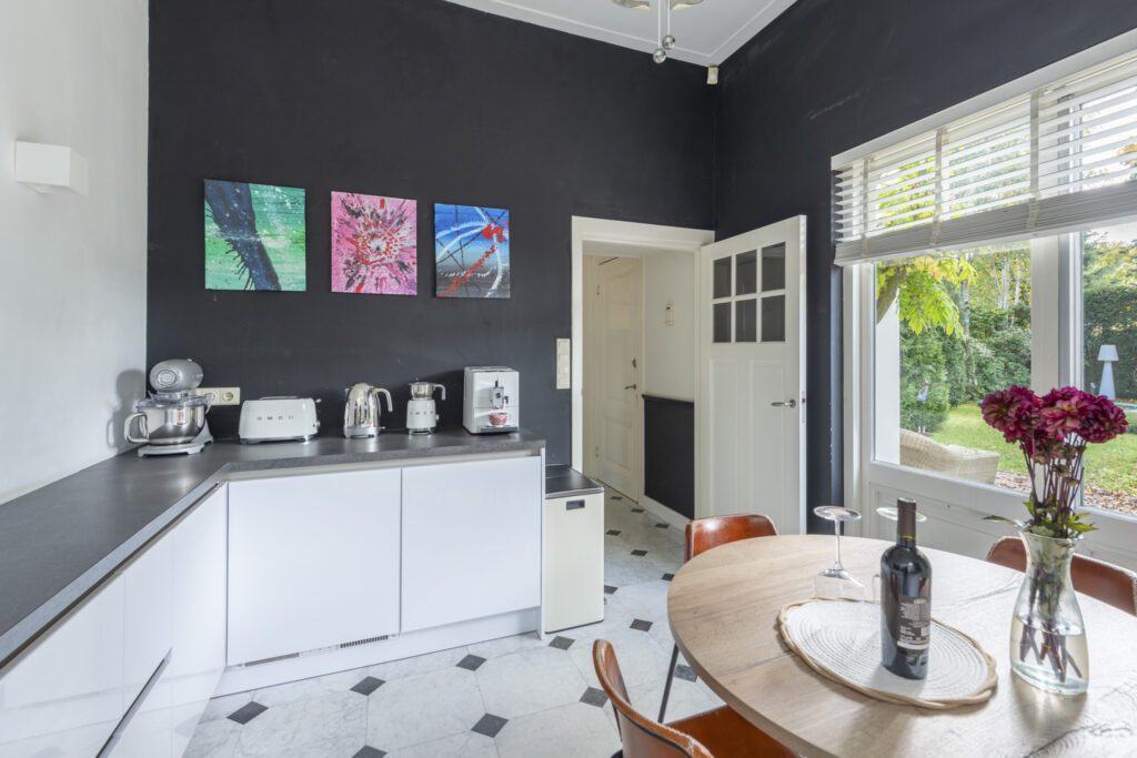 Modern kitchen with appliances, table, and window view.