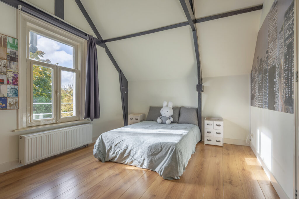 Cozy bedroom with stuffed bunny on bed.
