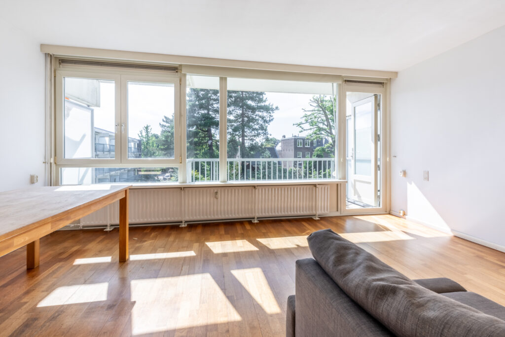 Bright living room with large windows and wooden floor.