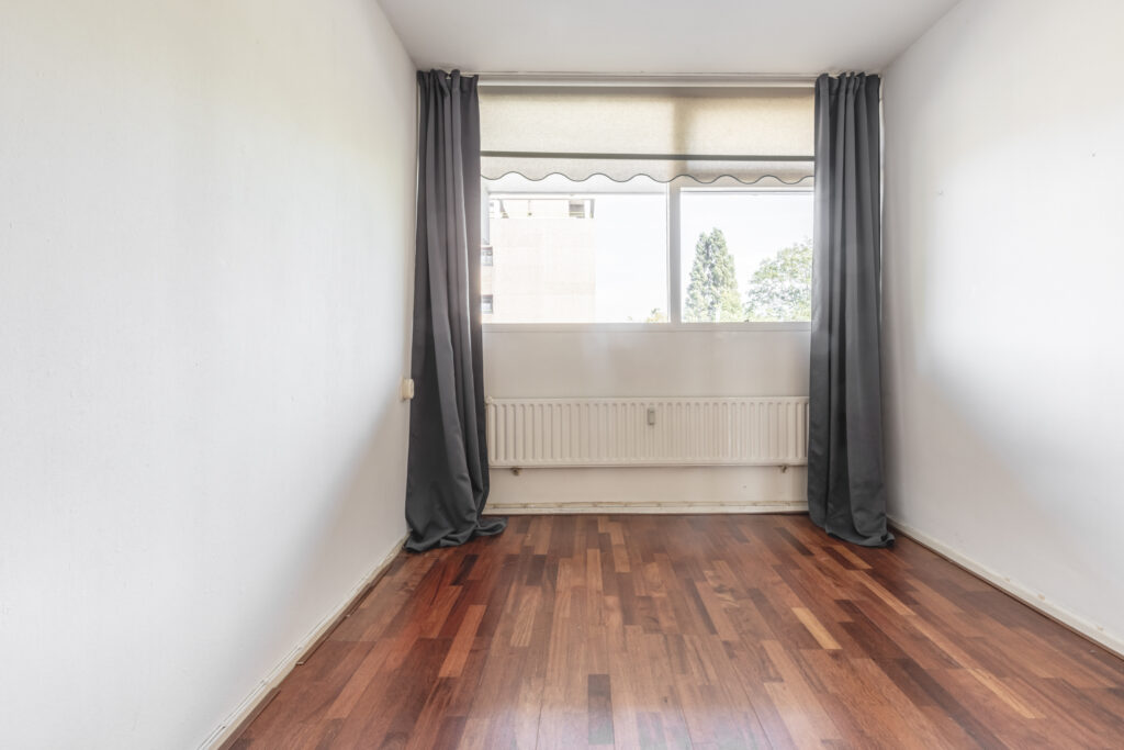 Empty room with wooden floor and large window
