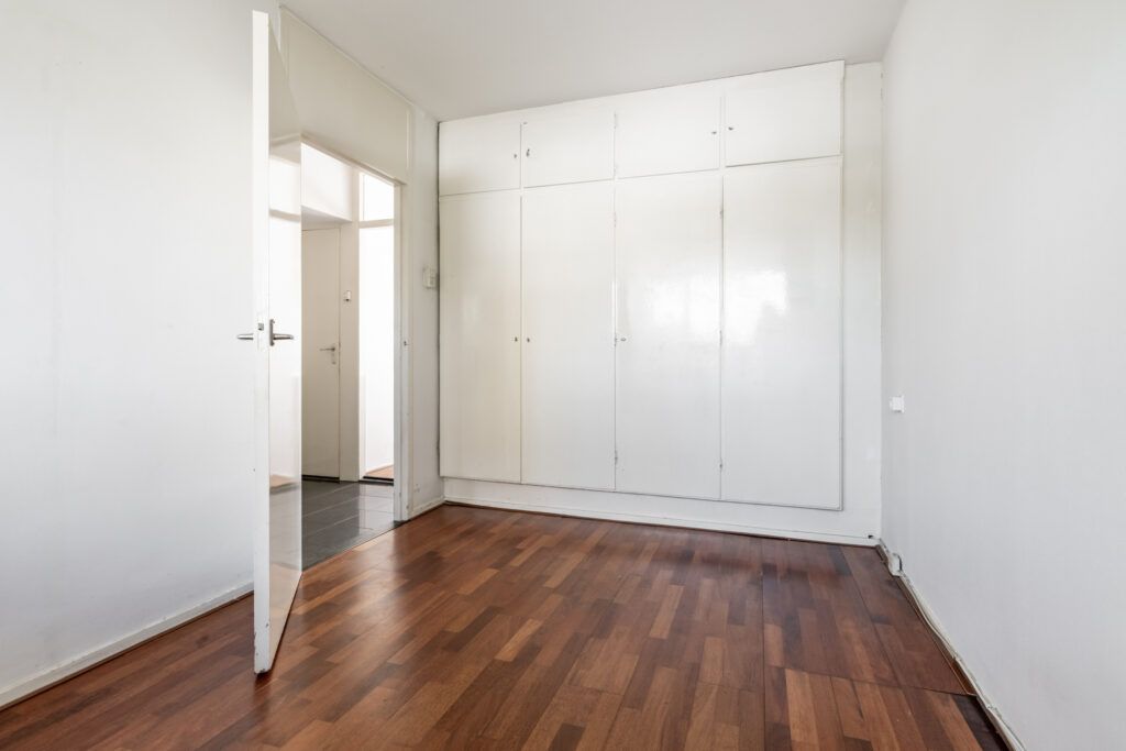 Empty room with wooden floor and white closet.