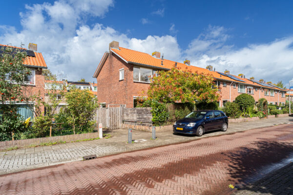 Residential street with parked car and row houses