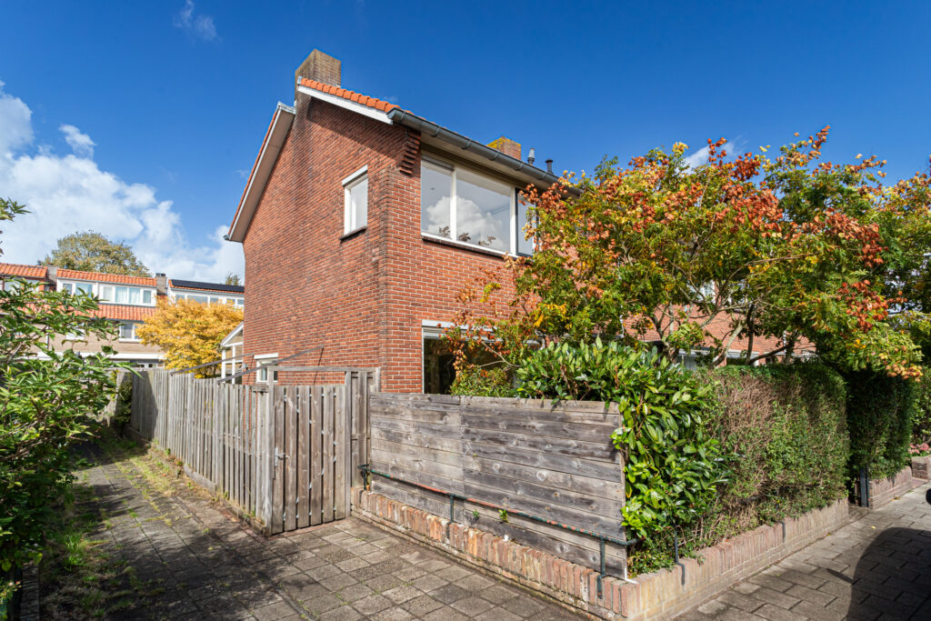 Brick house with autumn foliage, blue sky