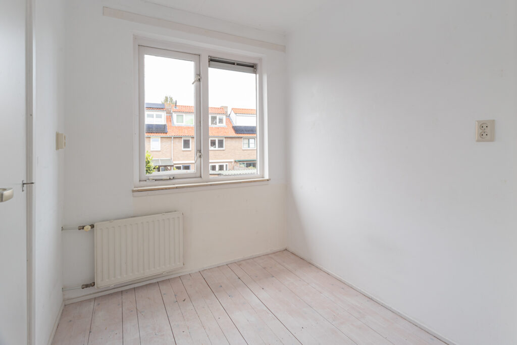 Empty white room with window and radiator