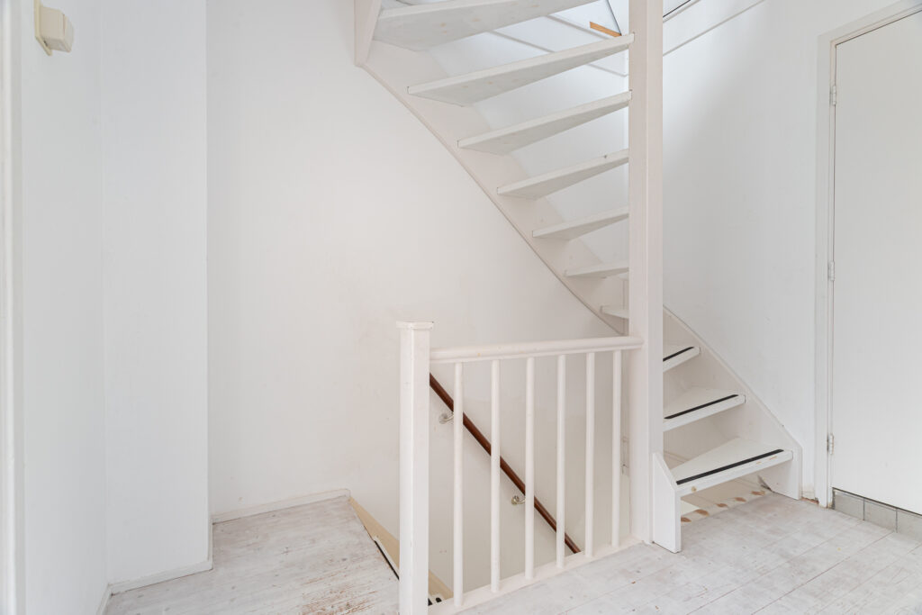 White wooden spiral staircase in a minimalist interior