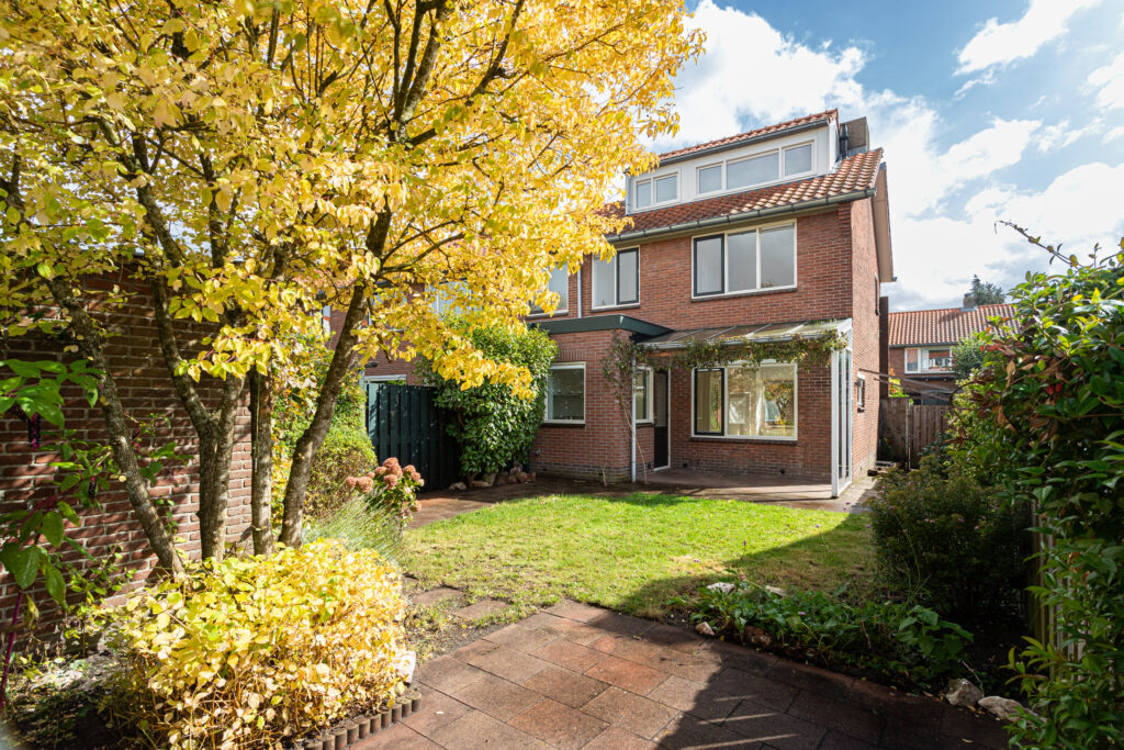 Brick house with garden and autumn trees