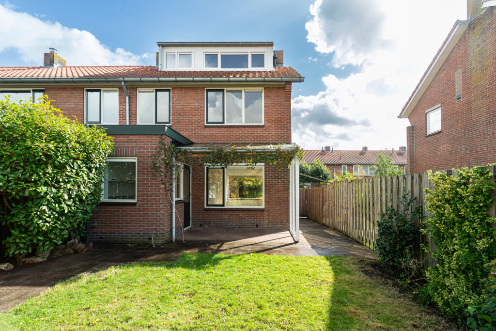 Brick house with garden and wooden fence