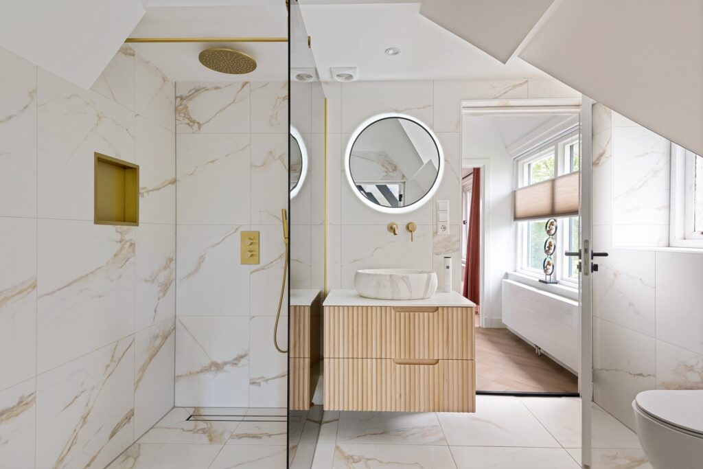 Modern bathroom with wood accents and round mirror.