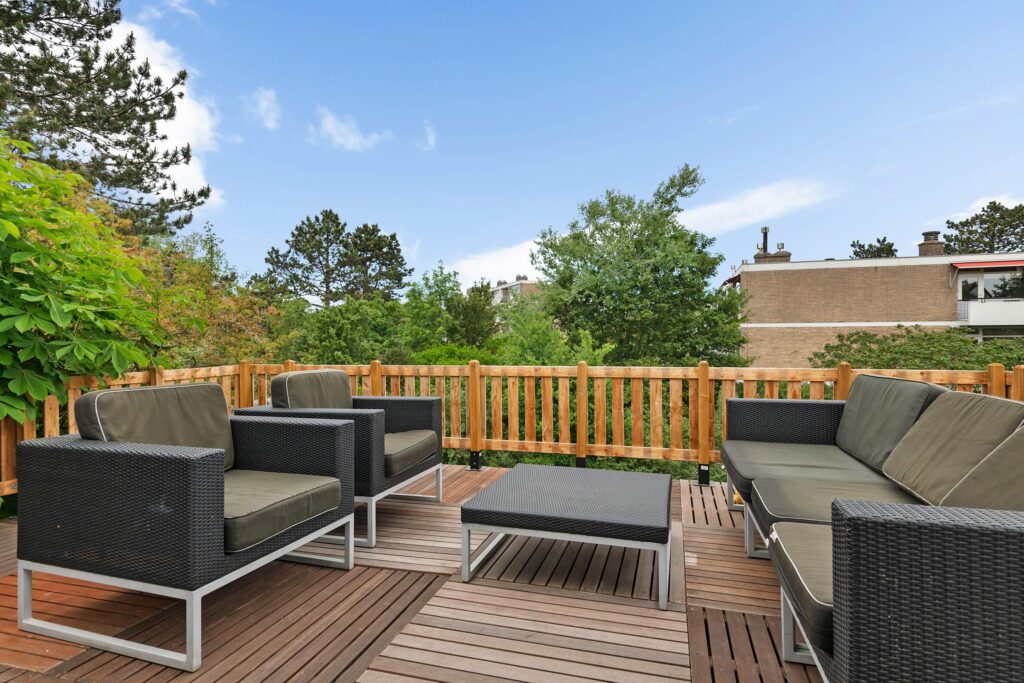 Outdoor patio with wicker furniture and wooden deck