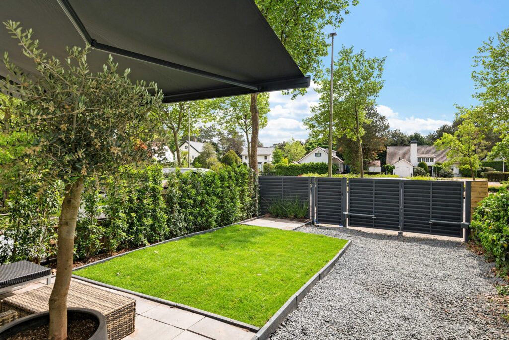 Modern backyard with patio, lawn, and privacy fence.