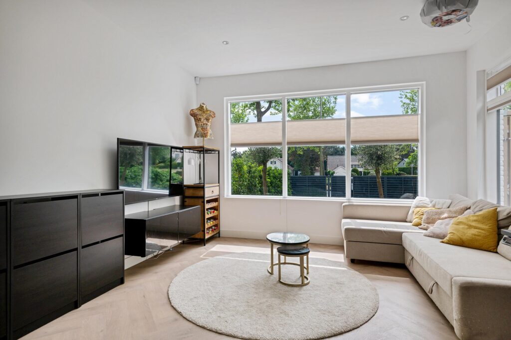 Modern living room with large window and cozy sofa.