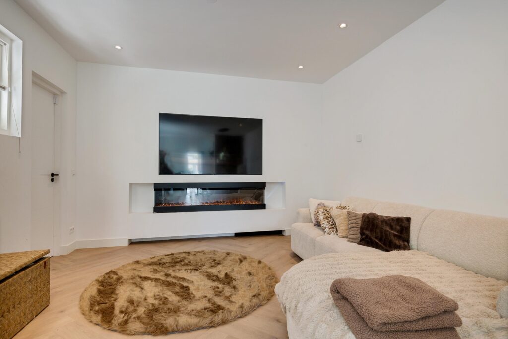 Cozy living room with TV and electric fireplace.