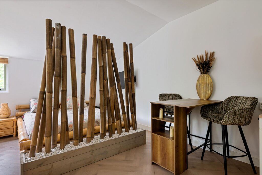 Cozy bedroom with bamboo divider and desk area.