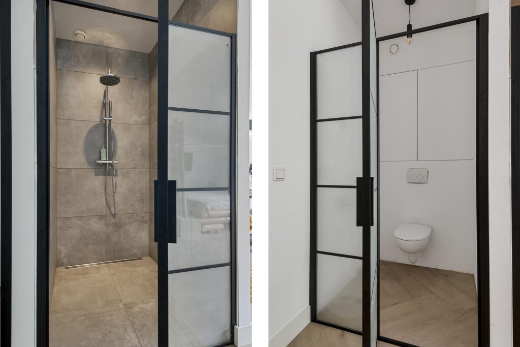 Modern shower and toilet with glass doors.