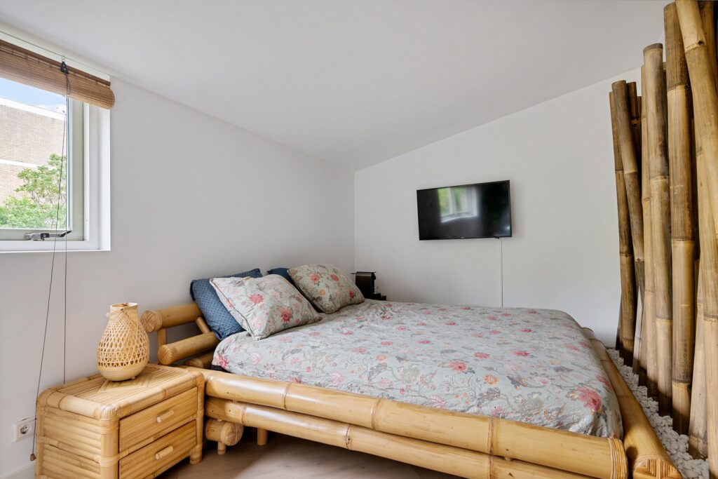 Cozy bedroom with bamboo furniture and floral bedding.