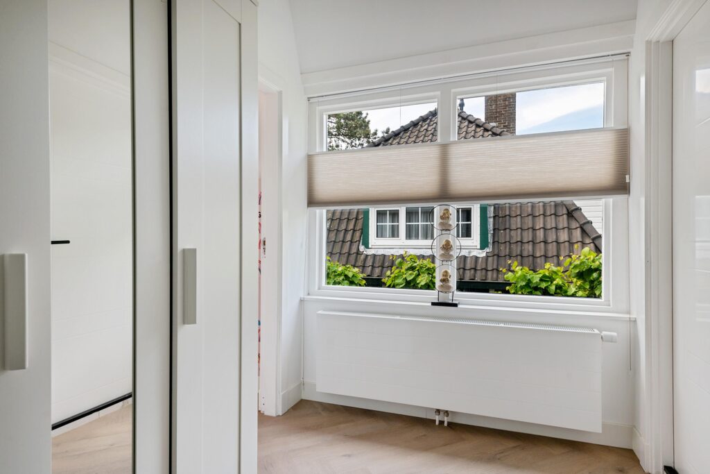 Bright white hallway with large window shade.