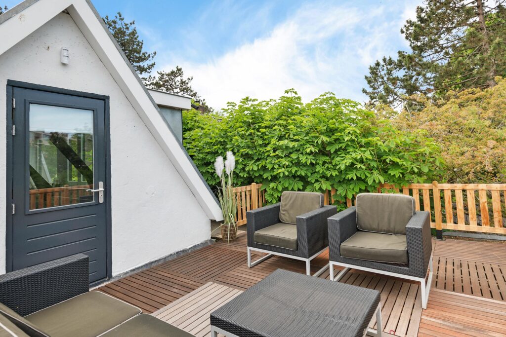 Outdoor patio with chairs and greenery