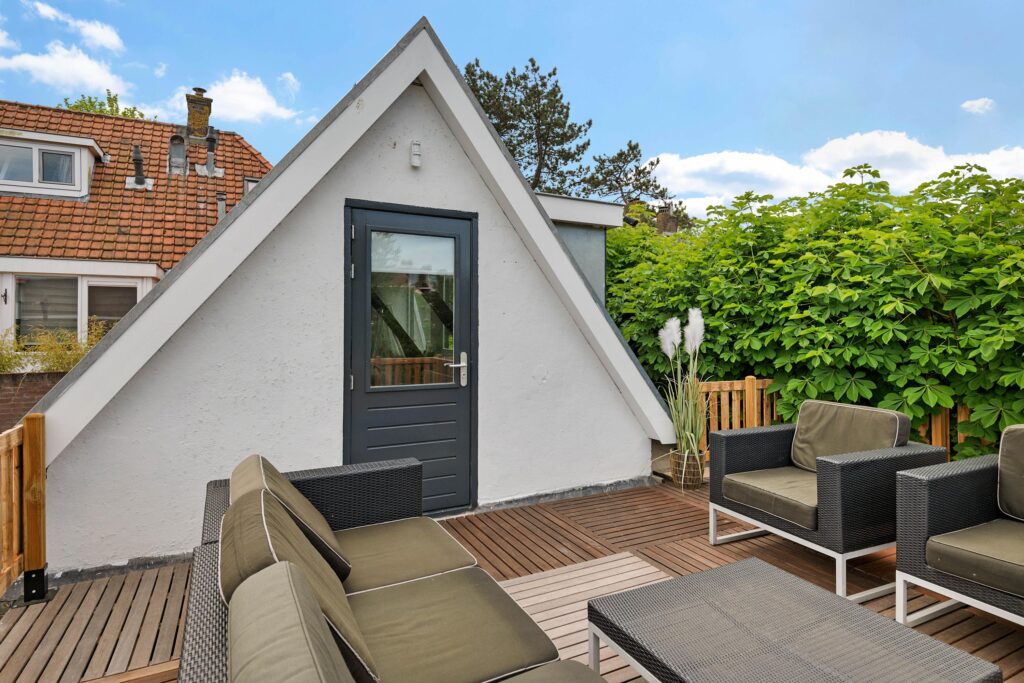 Cozy rooftop terrace with seating and greenery.