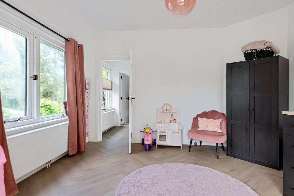Child's room with pink decor and toys.