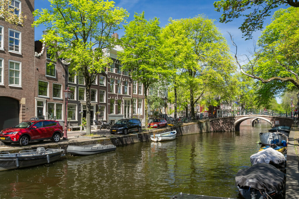 Scenic Amsterdam canal with boats and bridge.