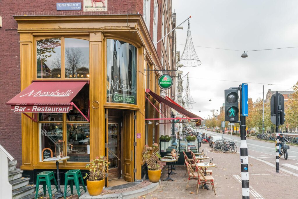 Charming corner restaurant with outdoor seating on busy street.