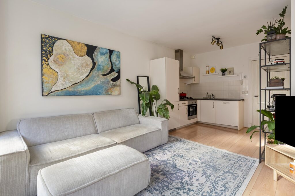 Modern living room with kitchen and abstract painting.