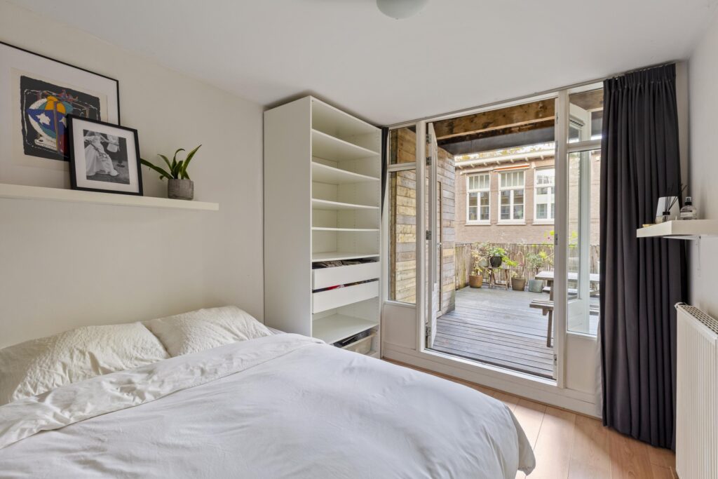 Cozy bedroom with balcony and modern decor.