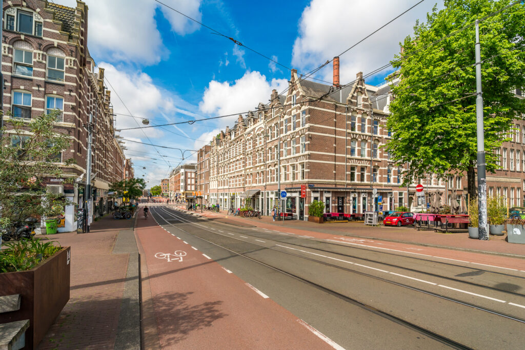 Street view of Amsterdam buildings and tram tracks.
